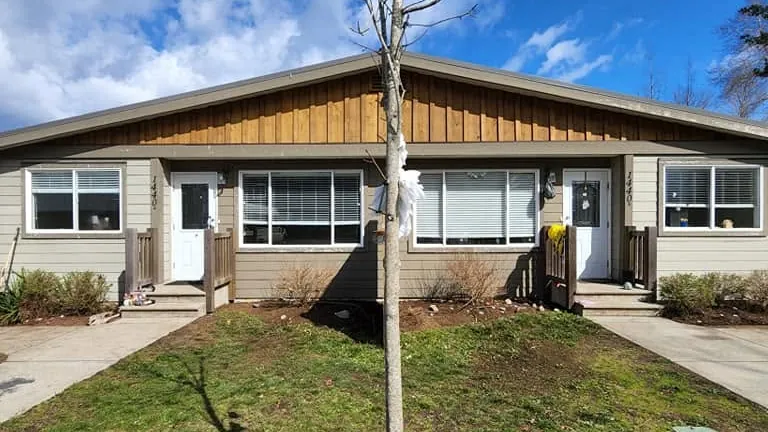 After: the same duplex with tidy beds, a clear lawn and the clutter gone