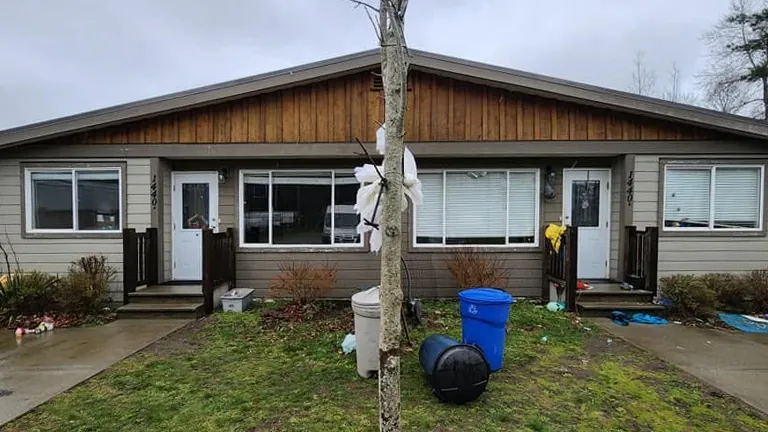 Before: a duplex front yard with garbage bins, clutter and overgrown beds